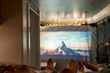 Cozy RV rental experience: feet up, enjoying a movie with the iconic Paramount logo projected inside.