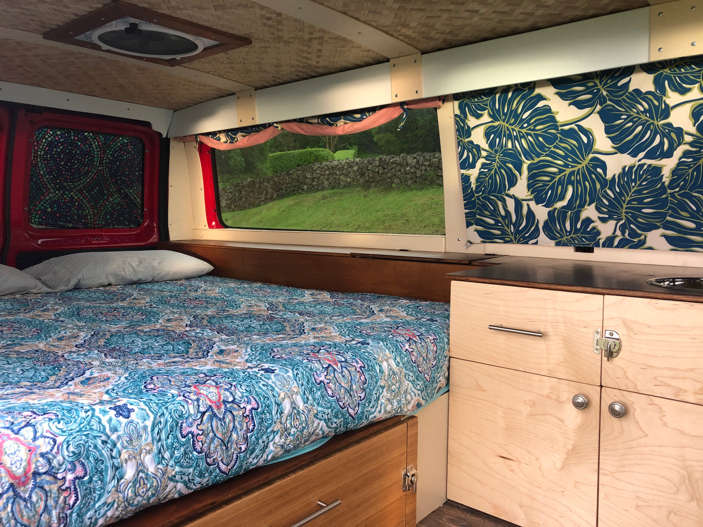 Cozy RV rental interior with bed, kitchen, and window view. Perfect for van life adventures.