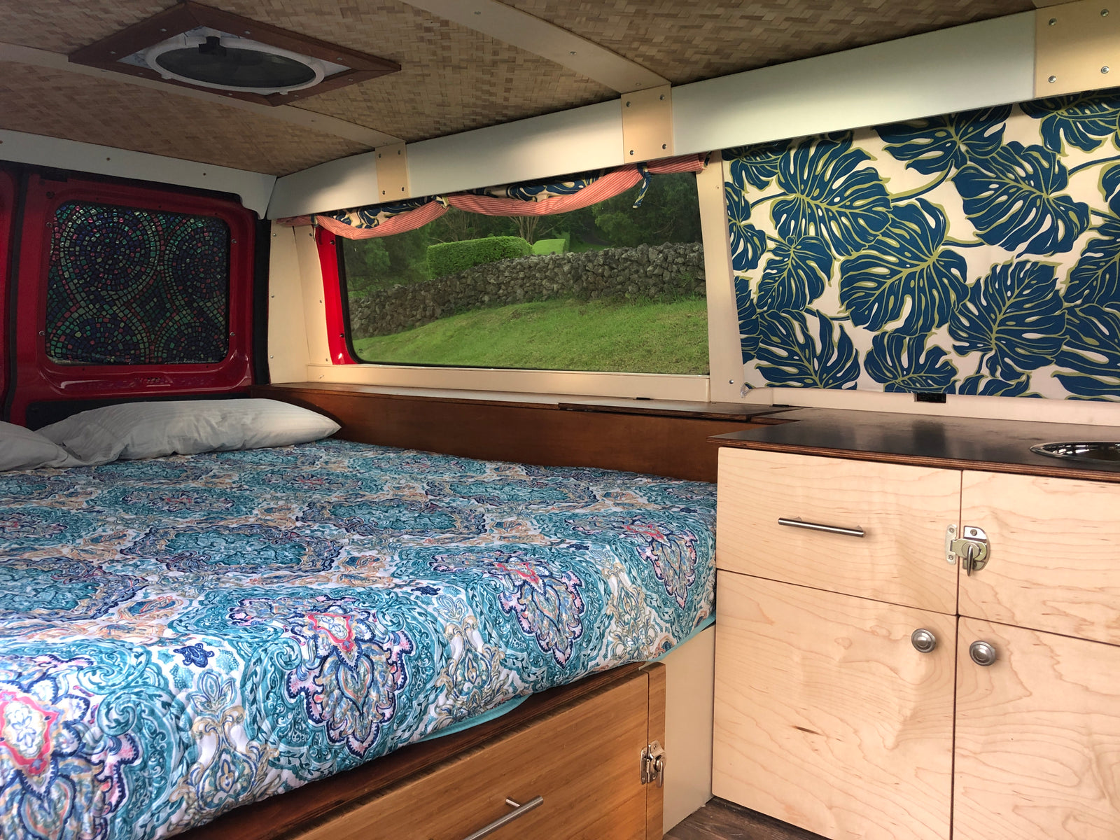 Cozy RV rental interior with bed, kitchen, and window view. Perfect for van life adventures.