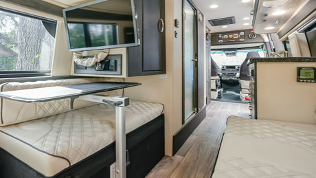 Step into this elegant RV rental! Interior boasts plush quilted seating, a mounted TV, adjustable table, and functional amenities.