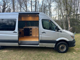 Inside an RV rental: a silver camper van with a beautifully crafted wood kitchen and interior, ready for adventures.