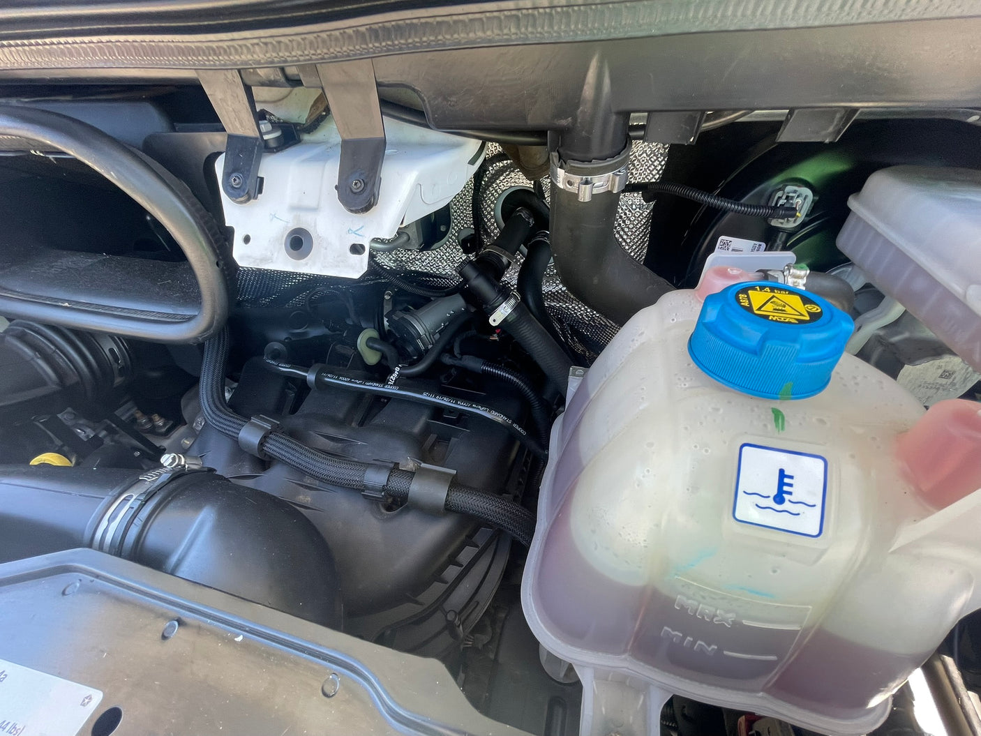 RV rental engine compartment. Close-up of coolant reservoir, hoses, and mechanical parts, crucial for vehicle health.