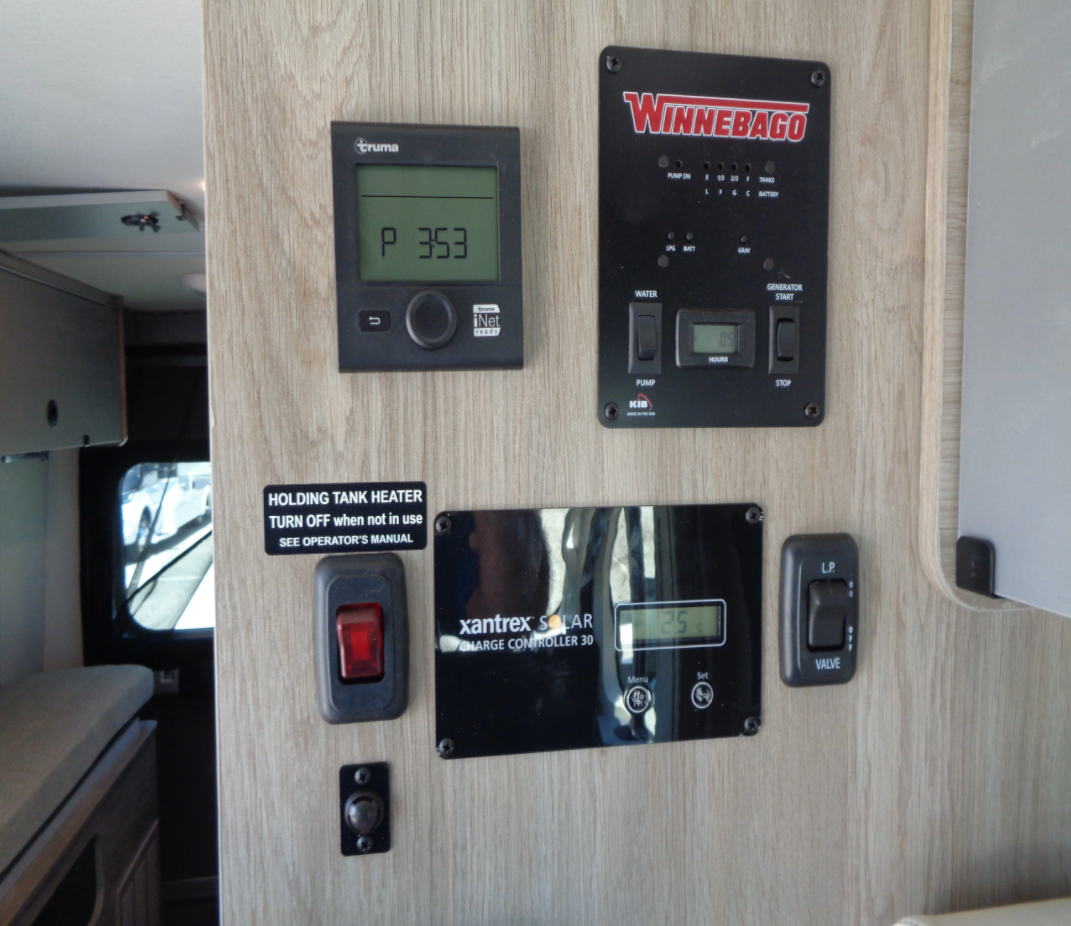 RV rental control panel featuring Truma heater, Winnebago system, Xantrex solar charger, and switches for tanks/LP valve.