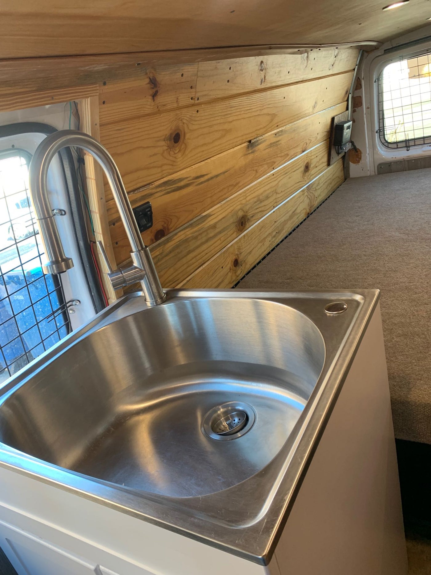  and an insulated window panel.|Inside an RV rental's under-sink cabinet: a white interior with visible plumbing — photo 11