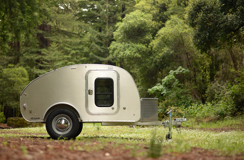 Silver teardrop RV rental rests in a lush forest clearing. Perfect for camping, travel, and outdoor adventures. — photo 5