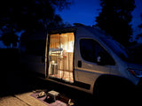 Cozy RV rental campervan at night with illuminated interior, perfect for camping adventures.