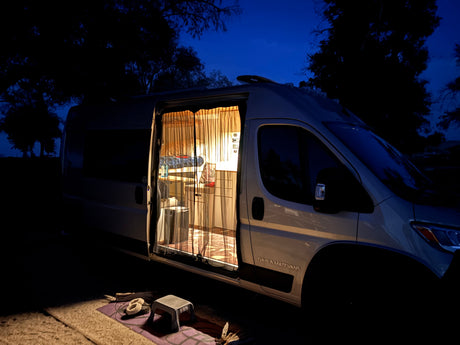Cozy RV rental campervan at night with illuminated interior, perfect for camping adventures.