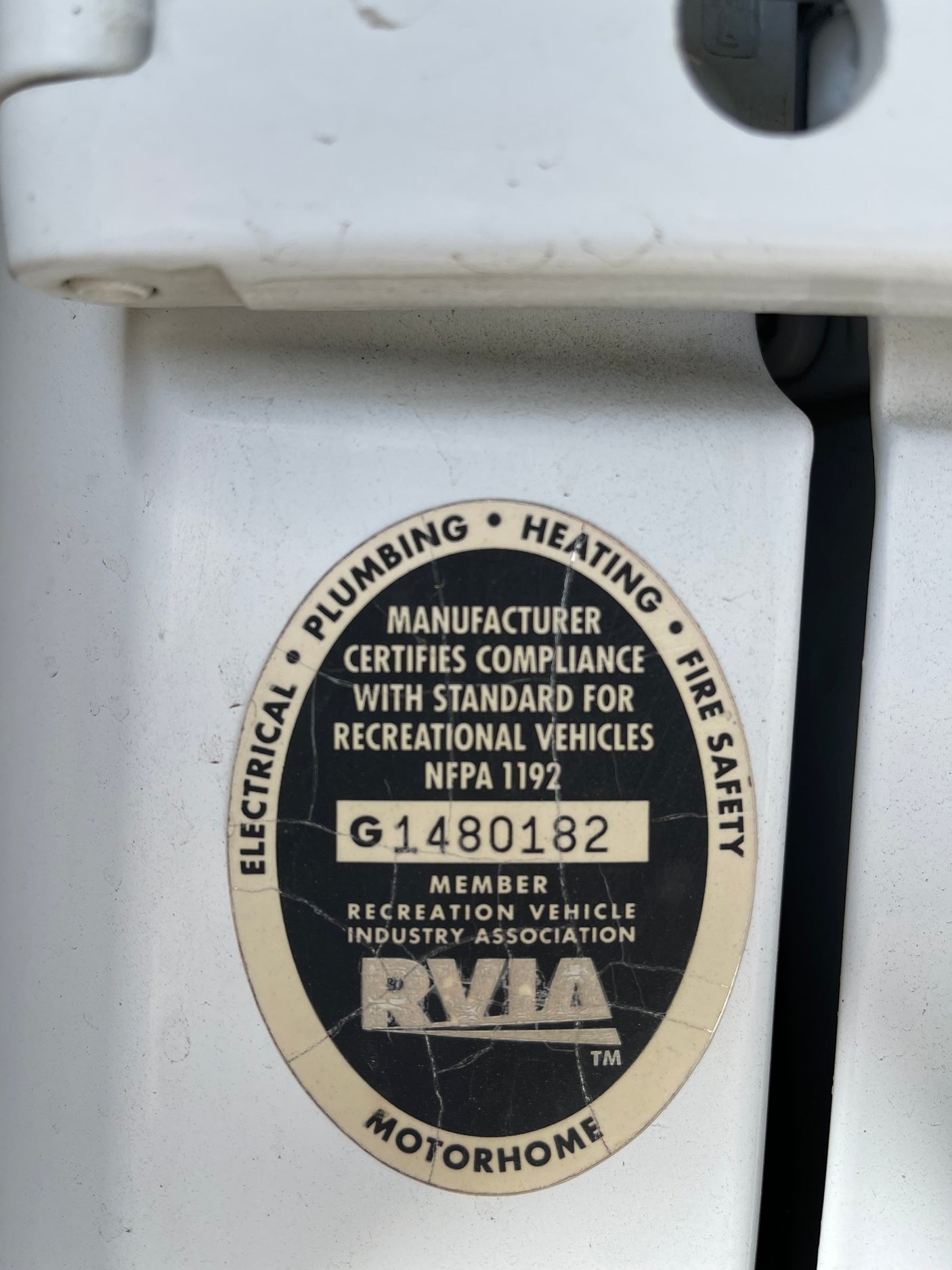 Close-up of an rv rental's RVIA certification, detailing compliance for electrical, plumbing, heating, and fire safety.