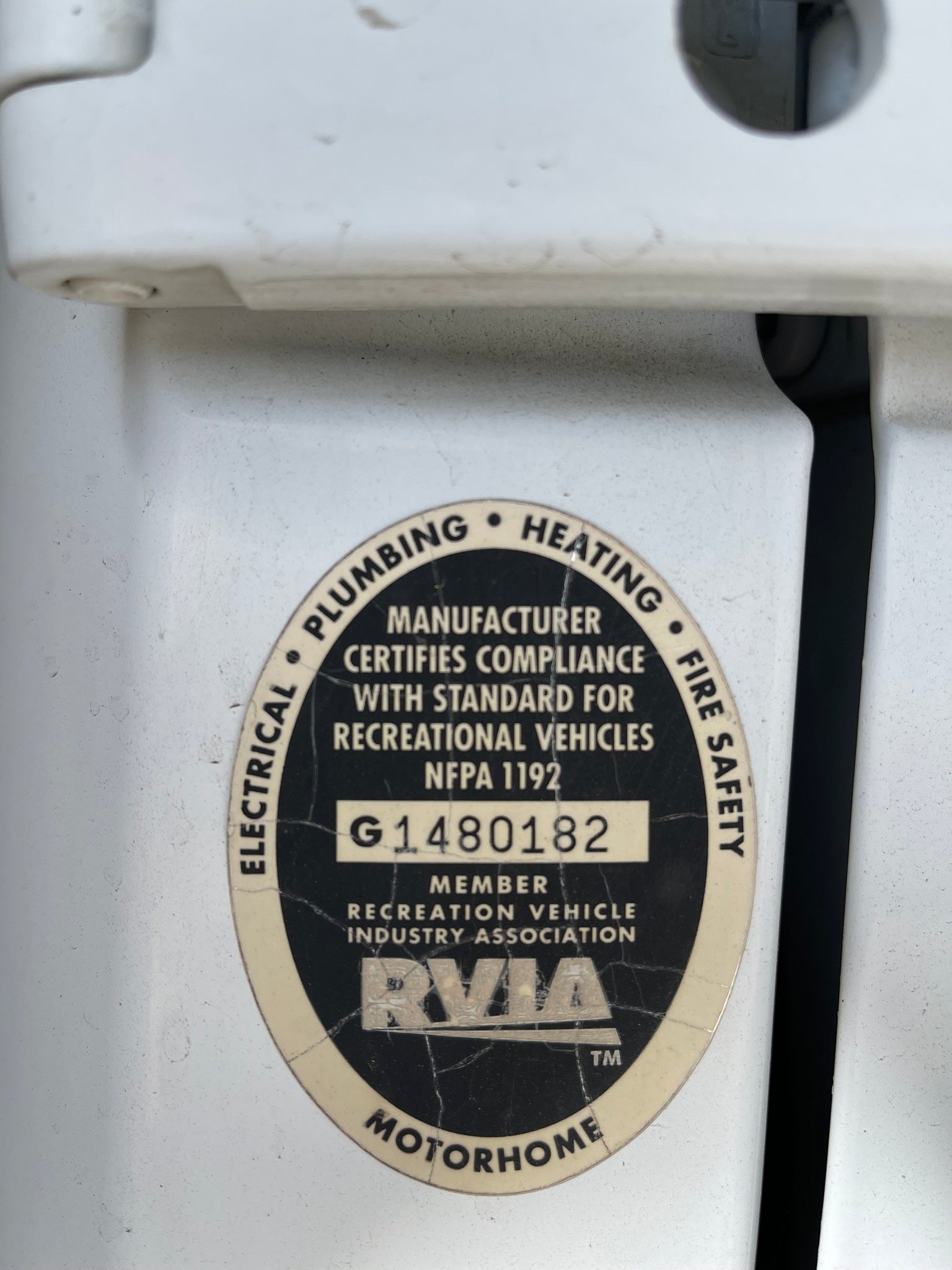 Close-up of an rv rental's RVIA certification, detailing compliance for electrical, plumbing, heating, and fire safety.