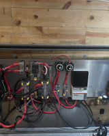 RV rental power hub: complex electrical wiring, fuses, battery switches, and a TriStar solar charge controller visible.