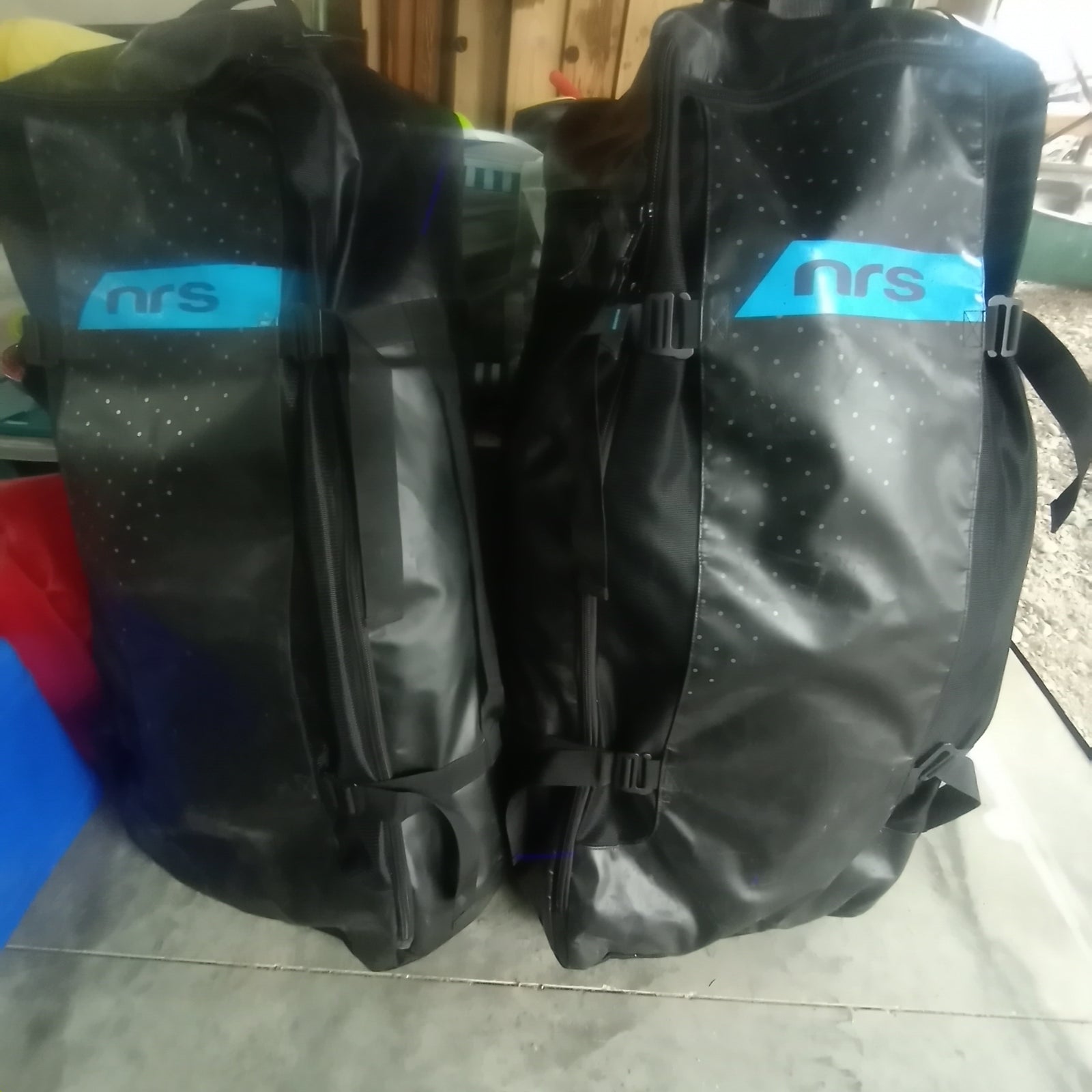 Two black NRS waterproof gear bags, ideal for storing essentials on your RV rental journey or any outdoor adventure.