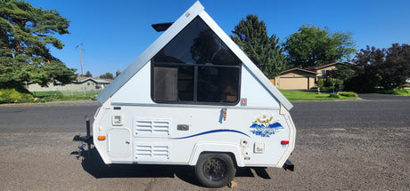 Compact A-frame rv rental, a white pop-up camper, ready for your next travel adventure and camping trip.