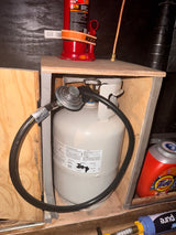 Essential gear for your RV rental: a propane tank, hydraulic jack, and various supplies neatly stored.