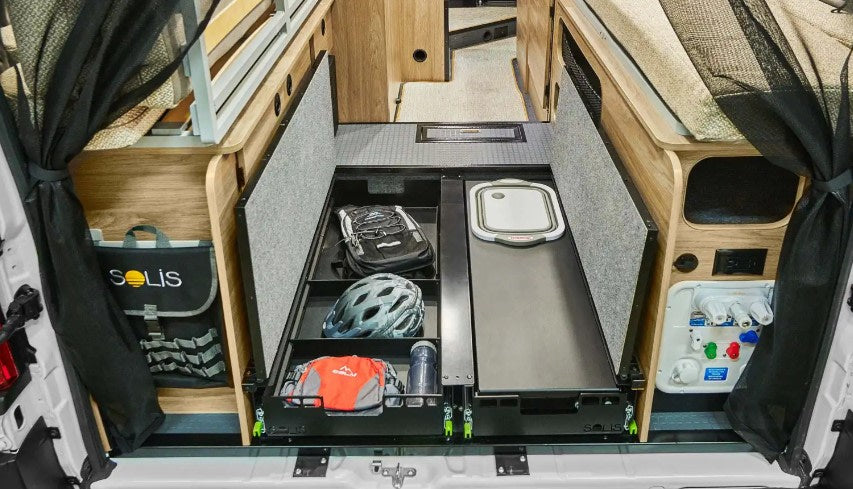  and a small wall-mounted storage shelf.|Inside a modern RV rental: compact kitchen with two-burner stove — photo 12