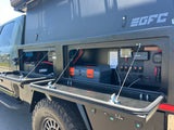 An RV rental truck's open side compartments reveal a sophisticated off-grid power system with batteries, Renogy, and charging ports.