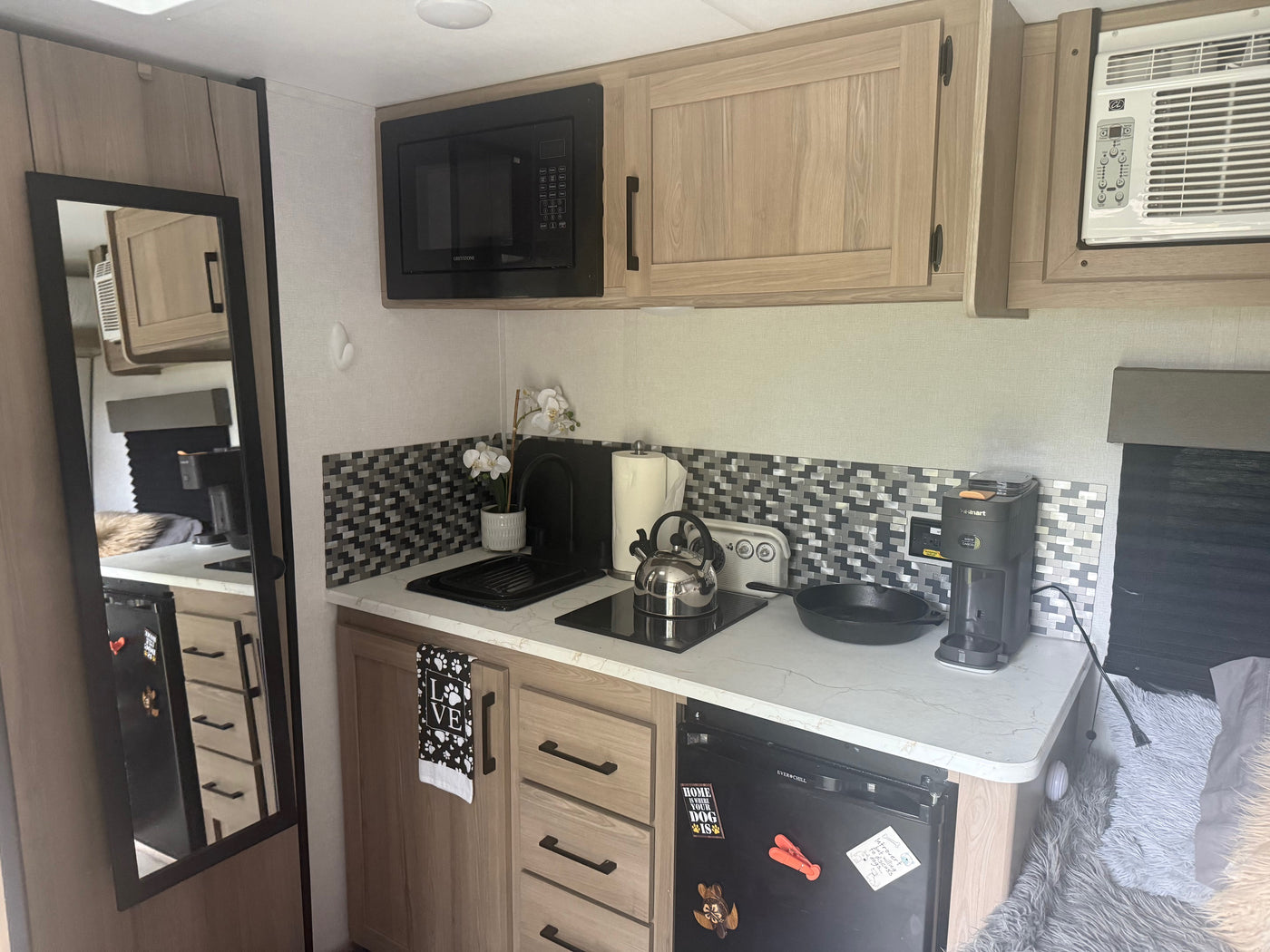 Functional RV rental kitchen: microwave, stove, coffee maker, fridge, and pet-friendly touches for cozy travel. — photo 4