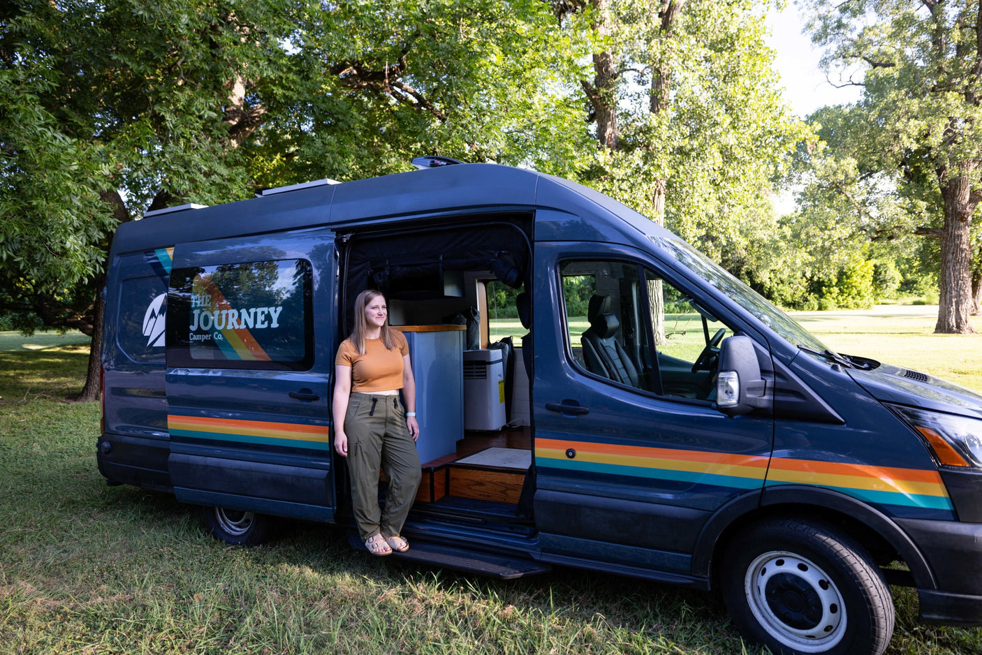  grassy park.|Dark gray camper van for RV rental