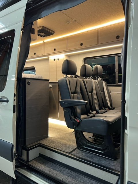 Inside an RV rental: versatile interior with foldable seats, sleek cabinetry & ambient lighting for comfy journeys.