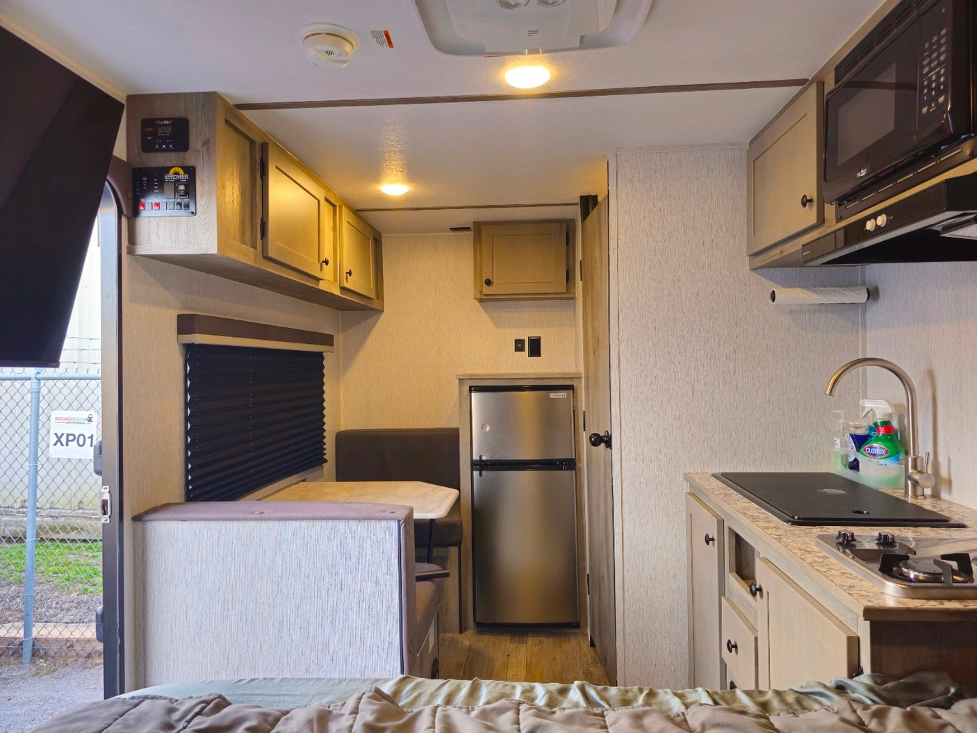 Cozy rv rental interior with kitchenette, dinette, and sleeping space. Features fridge, stove, microwave for travel comfort.
