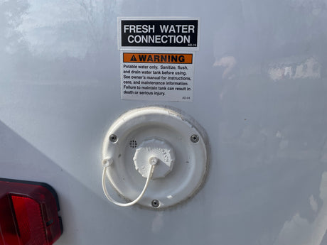 RV rental: fresh water connection and warning for potable tank sanitization, essential for safe use.