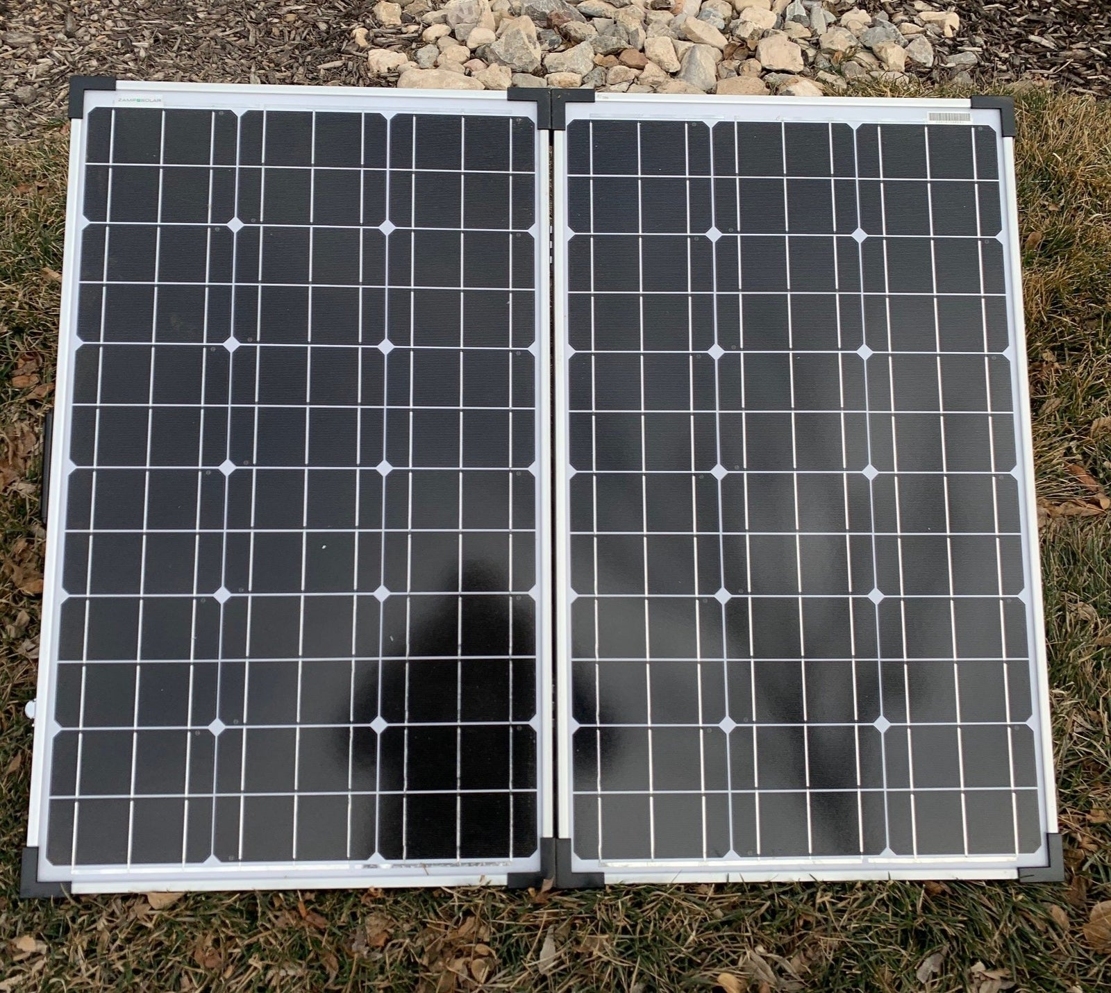 Portable, foldable Zamp Solar panels on grass. Essential for RV rental, off-grid charging, and camping.