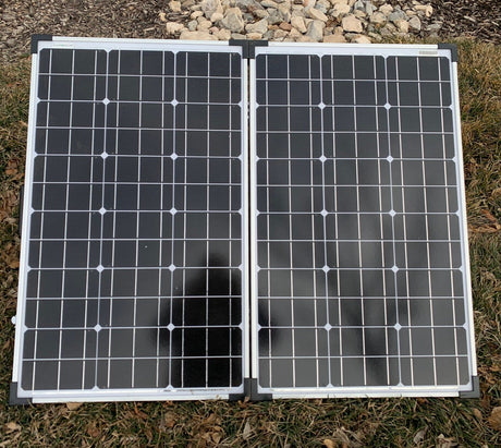 Portable, foldable Zamp Solar panels on grass. Essential for RV rental, off-grid charging, and camping.