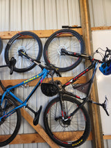 Mountain bikes and helmets organized on a garage wall, perfect for outdoor trips with an RV rental.