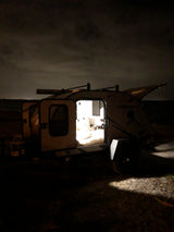 Cozy 'FREESOLO' RV rental illuminated at night, ready for serene camping trips and outdoor adventure.