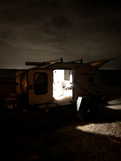 Cozy 'FREESOLO' RV rental illuminated at night, ready for serene camping trips and outdoor adventure.