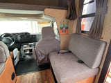 Spacious RV rental interior with comfortable seating, front cabin view, and decorative camping sign. Perfect for travel adventures.