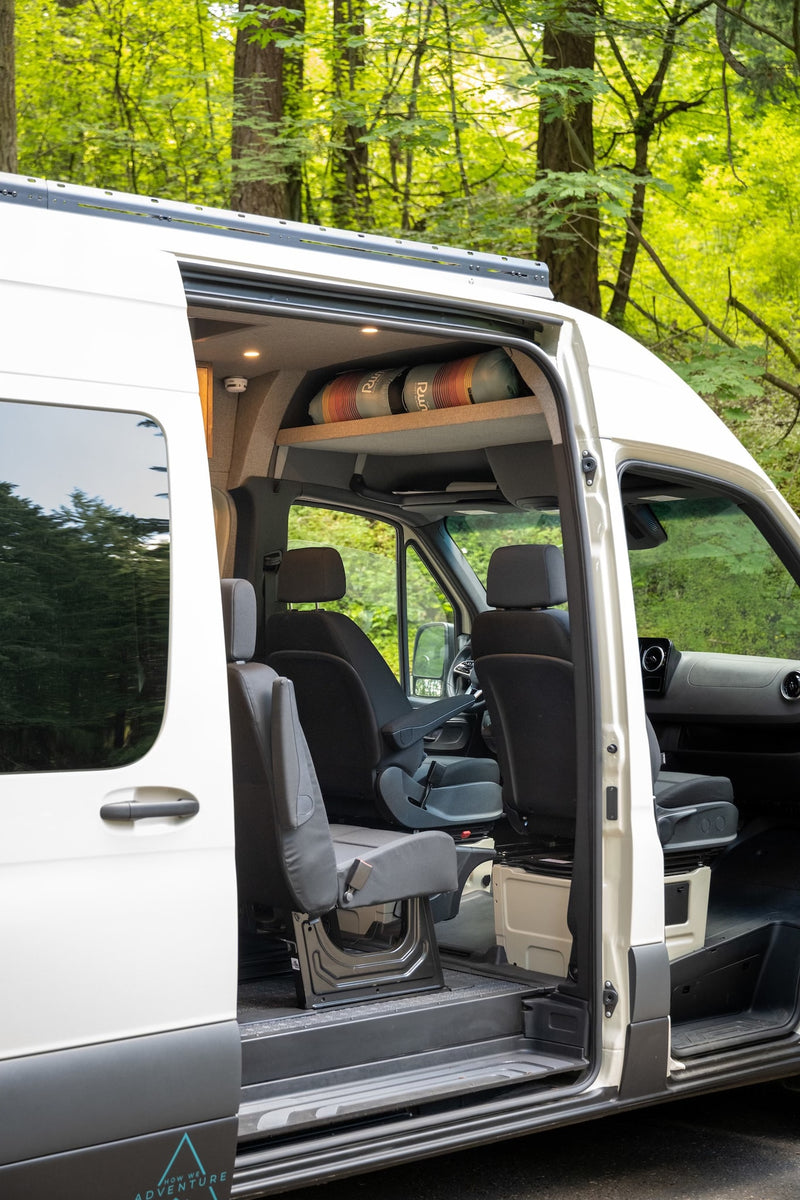 Spacious camper van interior, perfect for your next rv rental adventure. Open door reveals comfy seats and overhead storage in nature. — photo 3