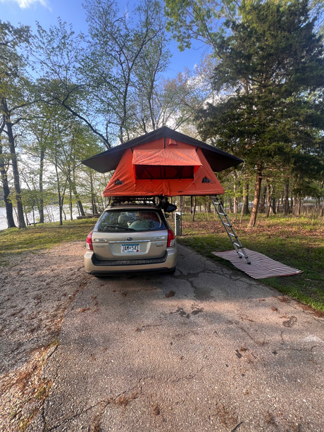 Rooftop tent camping with a Subaru Outback by the water, a compact option instead of an RV rental for outdoor adventure.
