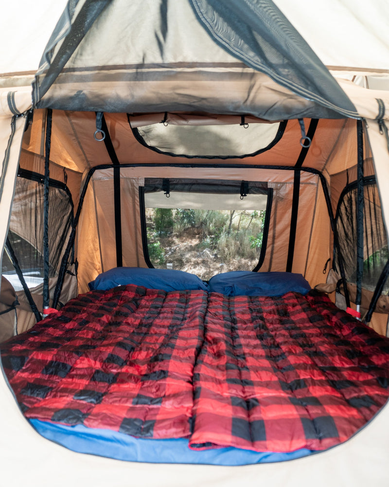 Cozy RV rental tent interior with a comfy bed, plaid bedding, and scenic window views for camping adventures. — photo 15