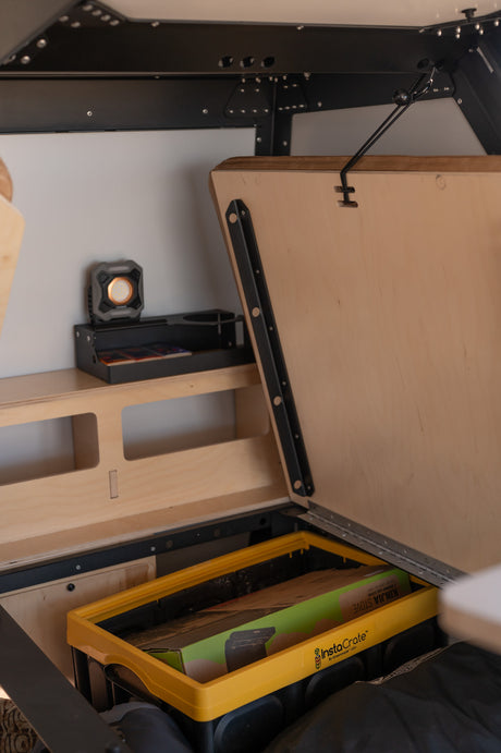 Optimized RV rental storage: Hidden compartment with a Kinjia stove in an InstaCrate & upper shelf for essentials.