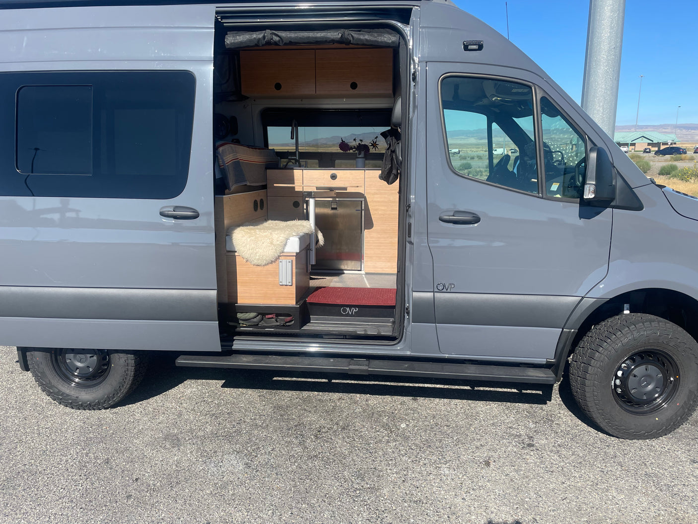 Gray camper van rv rental with open side door reveals a cozy, well-appointed interior for your next adventure.