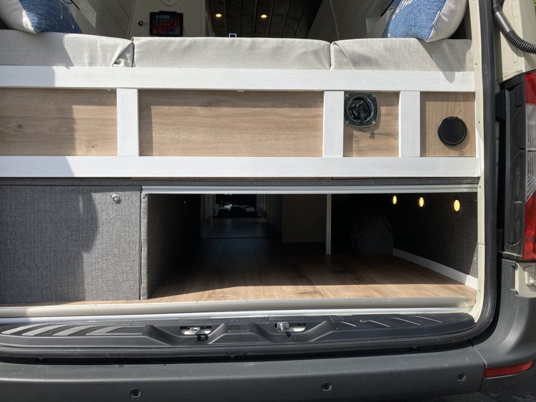  power panel & unique hexagon wood/moss wall decor. Modern camper features.|Explore this RV rental's modern interior featuring a compact kitchen with a black sink — photo 9