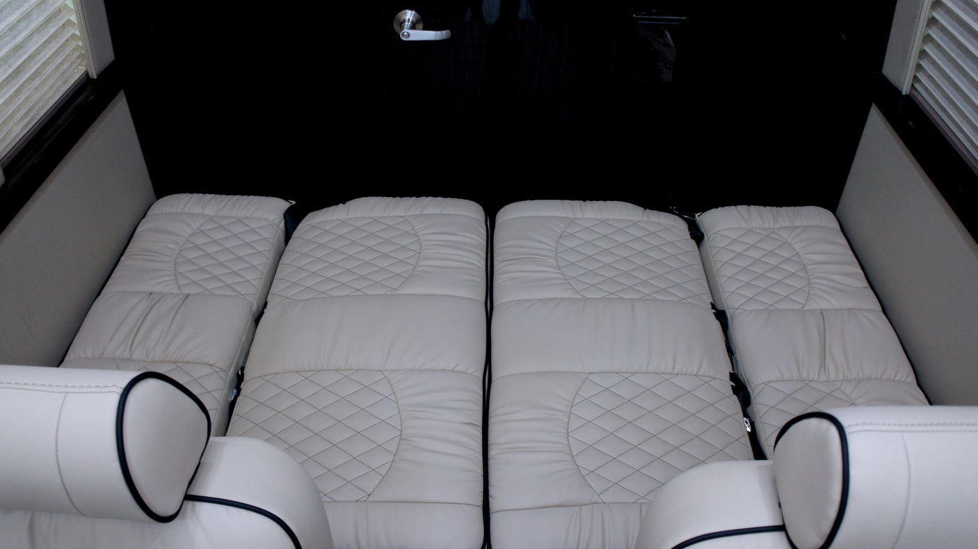 This RV rental offers a luxurious and comfortable sleeping area with quilted cream cushions.