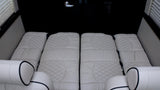 This RV rental offers a luxurious and comfortable sleeping area with quilted cream cushions.