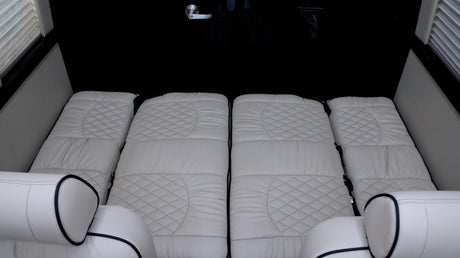 This RV rental offers a luxurious and comfortable sleeping area with quilted cream cushions.