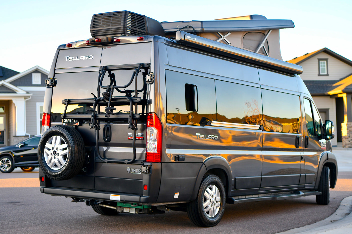 Reflections of sunset on this Thor Tellaro RV rental camper van with a pop-top, bike rack & spare tire.