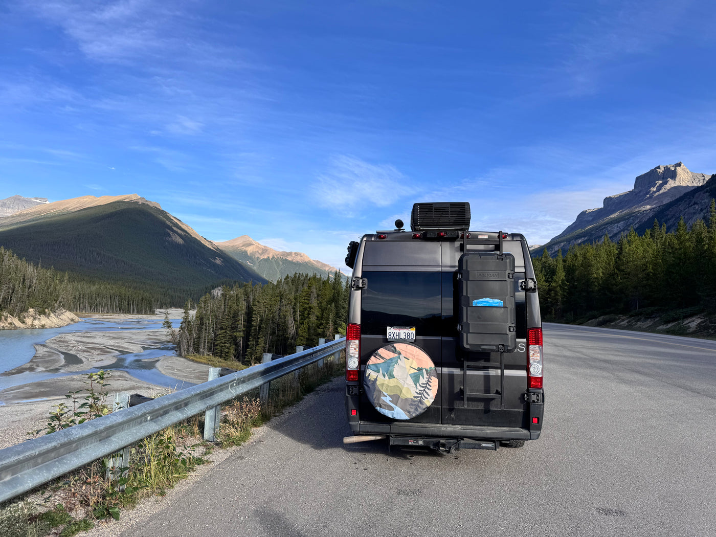 Rear view of a grey rv rental parked roadside, amidst majestic mountains and a river. Ideal for outdoor adventures. — photo 16