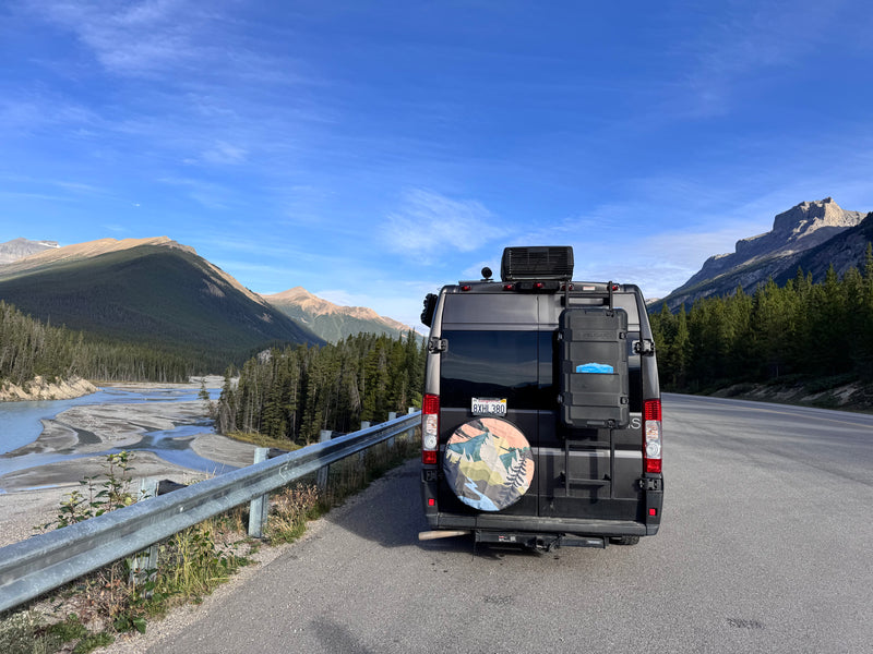 Rear view of a grey rv rental parked roadside, amidst majestic mountains and a river. Ideal for outdoor adventures. — photo 16