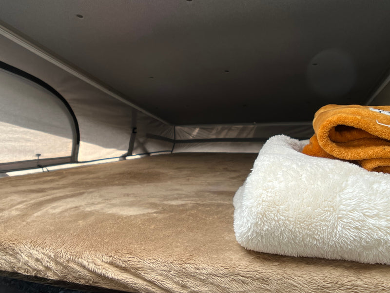 Cozy RV rental interior: soft brown bed with fluffy white and orange blankets. Ready for a comfortable night. — photo 11