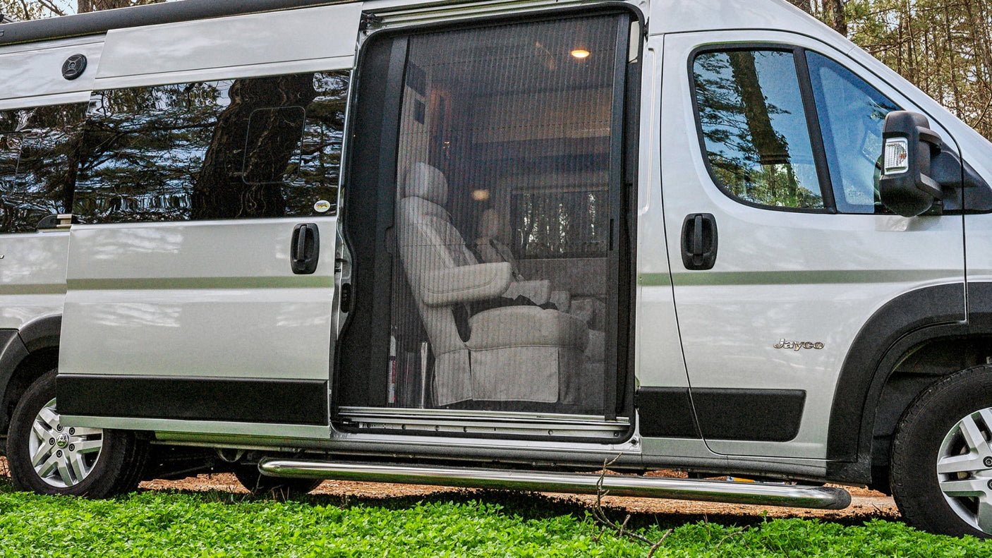 Silver Jayco RV rental with open side door and mesh screen, revealing interior swivel chairs. Ready for your next adventure.