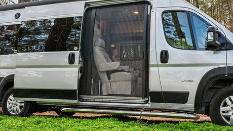 Silver Jayco RV rental with open side door and mesh screen, revealing interior swivel chairs. Ready for your next adventure.