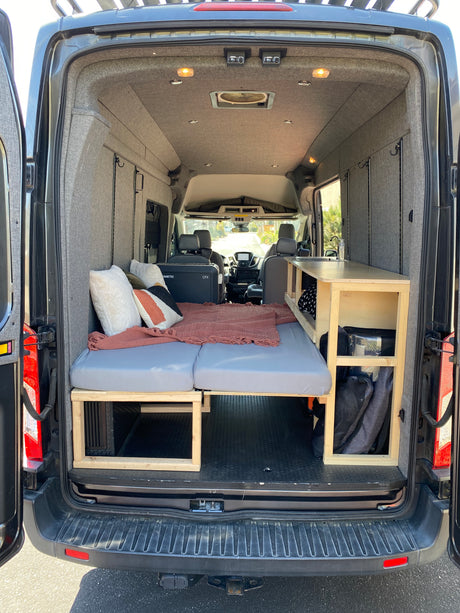 Spacious camper van interior, perfect for your next RV rental adventure. Features bed, kitchen, & ample storage.