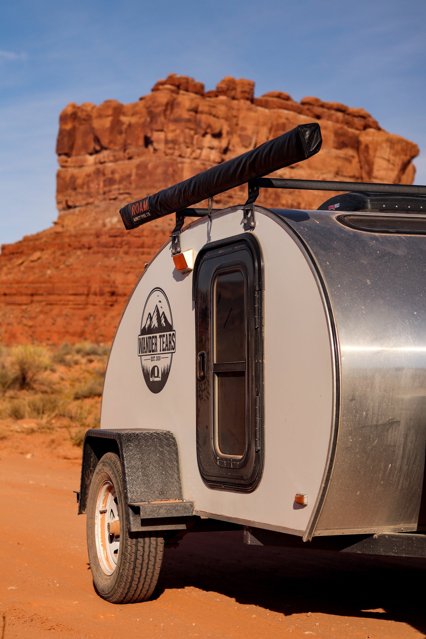 Teardrop RV rental camper on a dirt road, framed by towering red rock formations. Ideal for outdoor adventure. — photo 15