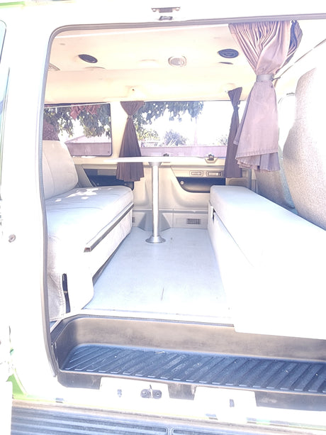 Functional rv rental interior with convertible sleeper sofas and dining table for comfortable travel.