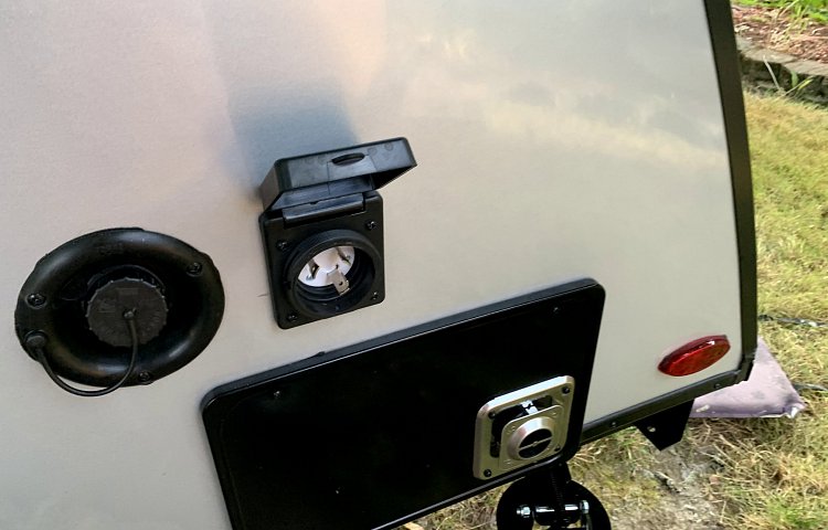 RV rental showing 30A shore power, water fill, and propane quick connect ports for camping hookups. — photo 15