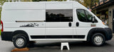 Side view of a white Ram ProMaster rv rental camper van, featuring a scenic mountain decal and tinted windows.
